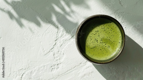 Matcha green tea cup seen from above on a white surface