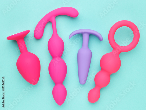 sex toys background. anal plugs and dildo over blue paper backdrop