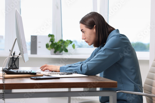 Woman with poor posture working in office