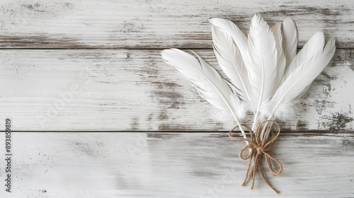 Soft white feathers on rustic wooden background, isolated on white. Natural texture for design projects, art prints, and creative backgrounds.