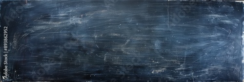 A closeup photo of a dark blue chalkboard surface with white erasure marks. The surface has a textured, grainy appearance