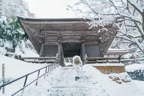 Woman tourist sightseeing Yamadera temple with snow in winter, traveler travel Risshakuji temple in Yamagata City, in Yamagata Prefecture, Tohuku, Japan. Landmark for tourists attraction in Japan