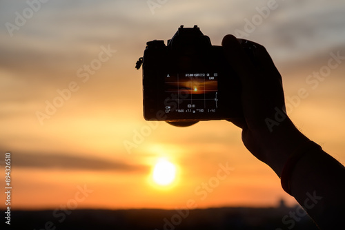 Fotograf robiący zdjęcia zachodzącymi słońcu 