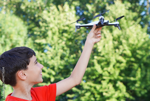 preteen boy playing with a drone in the field