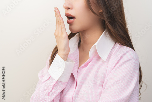 Portrait of pretty brunette hair, disgust smell bad strong asian young woman, girl checking her breath oral with hand expression face disgusting, dislike mouth odor. Isolated on white background.