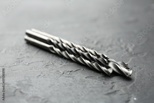 Three different drill bits on grey table