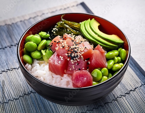 A bowl of colorful poke with fresh tuna, avocado, seaweed, edamame, and sesame seeds over