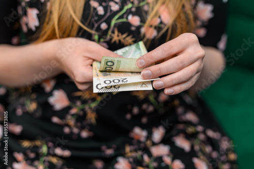 Zbliżenie na kobietę trzymająca w dłoni banknoty, polskie pieniądze 