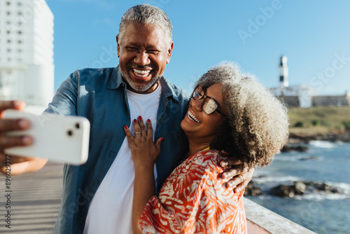 Golden Years: Cheerful senior couple taking a selfie on a sunny day by the sea