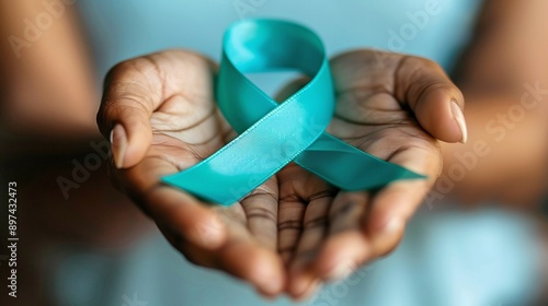 Teal ribbon on womans hand symbolizing awareness for ovarian cancer and PCOS. Concept Cancer Awareness, PCOS Awareness, Teal Ribbon, Health Advocacy