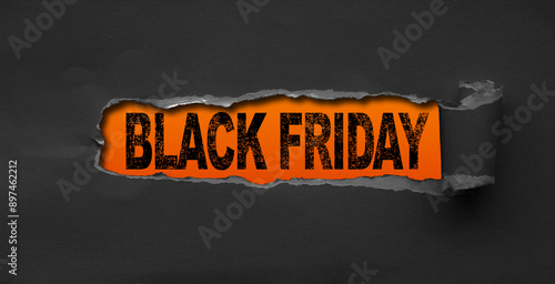 Top view of Black torn paper and the text black friday on a orange background. Black Friday composition.