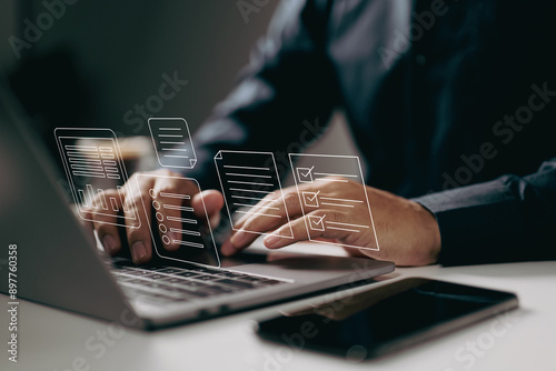 Typing on a laptop with digital documents and checklists floating above. It symbolizes the use of digital tools for task management, organization, and efficient workflow in a modern work environment.