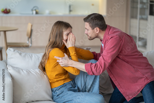 Tyrant husband shouting and shaking crying wife, arguing and grabbing her hands on sofa. Family quarrel, domestic violence and impossibility of escaping toxic relationships. Destructive power of abuse