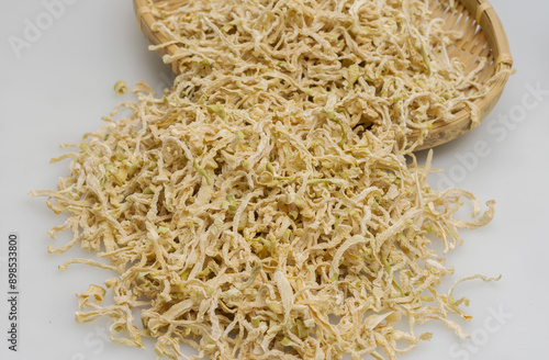 Close-up of stacked dried radish slices on white floor and bamboo basket, South Korea 