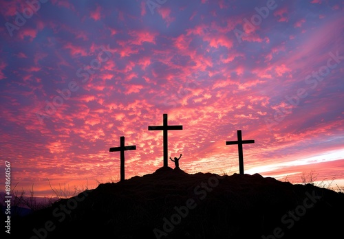 A silhouette of a person raising their hands in front of three crosses against a vibrant sunset sky, symbolizing hope and faith in a spiritual context. 