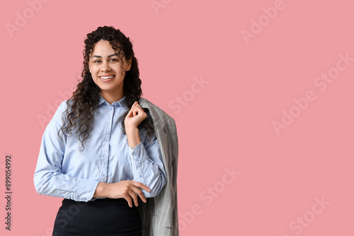 Happy young African-American woman in stylish blue collar shirt on pink background