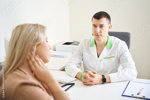 Woman complaining of cervicalgia to neurologist during initial consultation