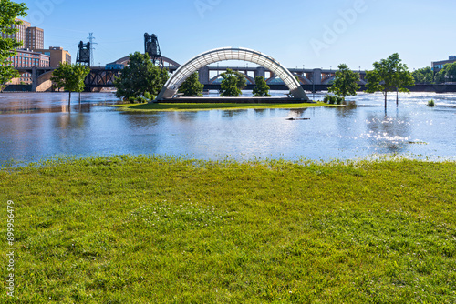 part of raspberry island regional park submerged under mississippi river floodwaters with bandshell visible and robert street bridge behind it