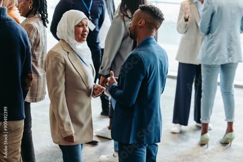 Networking event with diverse professionals engaging in conversation during a business conference