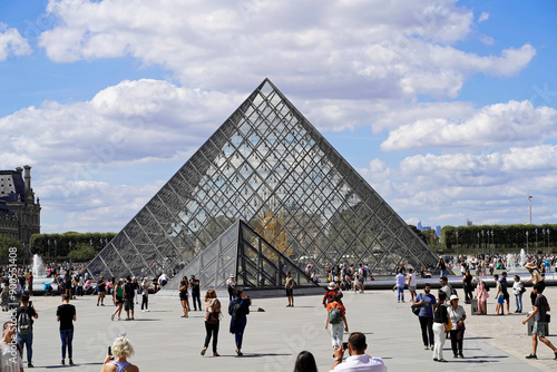 Glaspyramide im Innenhof des Palais du Louvre, Paris, Frankreich, Europa, Menschen laufen zwischen den Gebäuden und der Glaspyramide des Louvre in Paris bei sonnigem Wetter, Europa