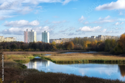 The urban landscape. Autumn in the city. The river and residential buildings. A sunny autumn day