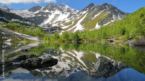 Reflections on The Lago Arpy (Arpy lake) located in the Italian Alps, La Thuile, Aosta Valley, surrounded by mountains and glaciers