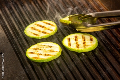 Rodajas de calabacín cocidas en una parrilla con marcas de asado.