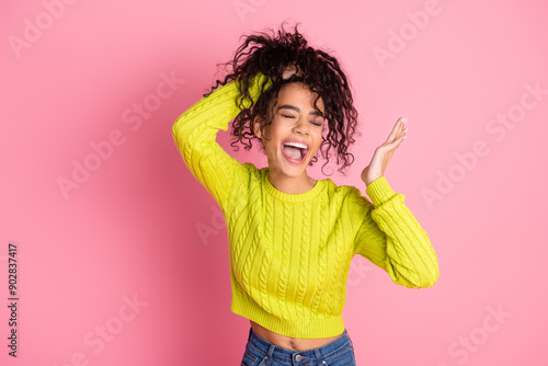 Portrait photo of youth model teenager girl funny laughing touching cheek making curly hair bun isolated on pink color background