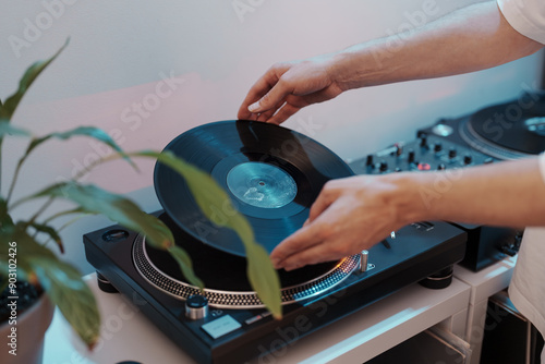 Person preparing to play music by putting a vinyl record on a DJ turntable.