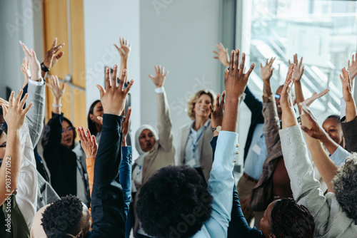 Diverse business group raising hands at conference event for team building and collaboration