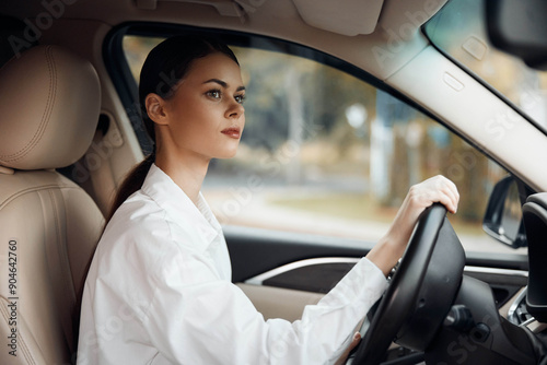 A woman confidently driving a car, hands on the steering wheel, looking directly at the camera, capturing a moment of focus and concentration on the road