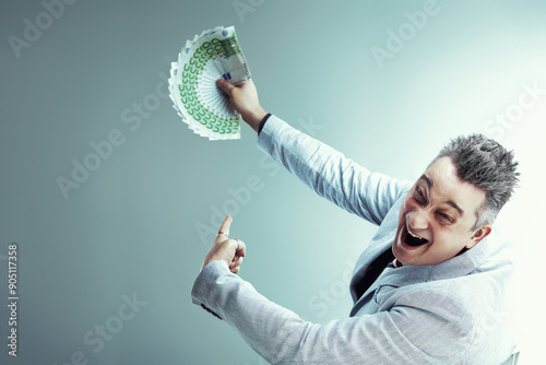 Sly salesman holding euro banknotes and pointing