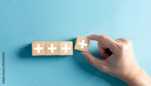 Value add concept. Hand place wooden cube with plus sign on light blue background. Positive 