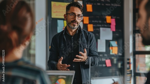 A professional trainer conducting an agile workshop in a conference room, interacting with participants and using visual aids.