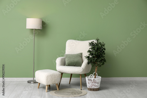 Interior of living room with armchair, pouf and lamp