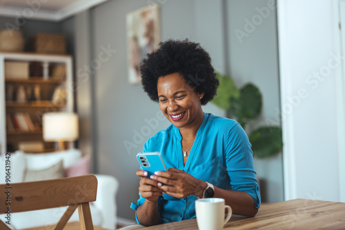 Mixed race mature attractive woman holding modern smartphone enjoy remote chat with friend. Learn new cool freeware application, share photos and videos in social media network, share messages concept