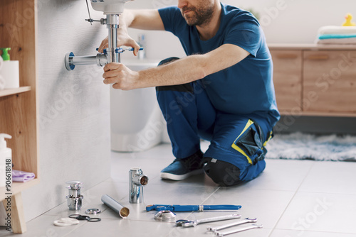 Expert plumber working on a bathroom sink drain