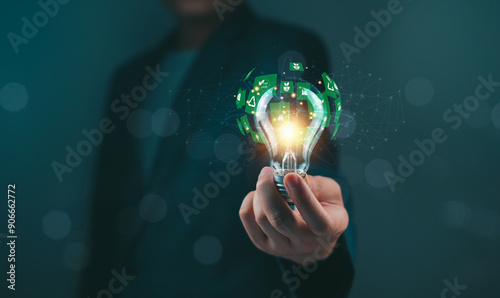 Person holding illuminated light bulb with green energy concept. Creative idea and innovation representation.