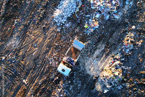 Landfill with waste disposal, aerial view. Garbage dump. Garbage truck unloads rubbish in landfill. Mustard gas among toxic waste in landfill. Landfill garbage truck, drone view.