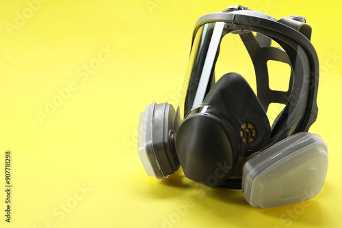 One full face respirator on yellow background, closeup. Space for text