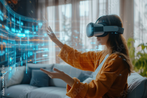 A young satisfied woman wearing a VR headset interacts with a holographic display, exploring virtual data through spatial technology in a modern living room.