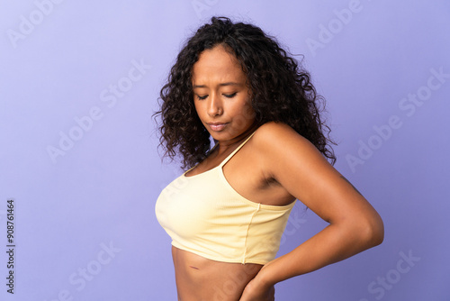 Teenager cuban girl isolated on purple background suffering from backache for having made an effort