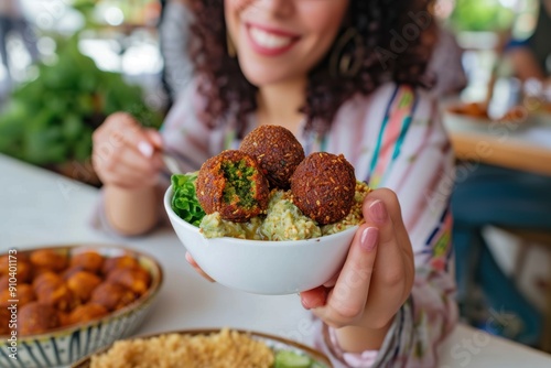 Woman Eating Falafel in a Restaurant Arabian style appetizer. Healthy vegan and vegetarian food concept.