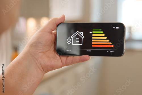 Smart Home Energy Management Displayed on a Smartphone in a Modern Kitchen Environment