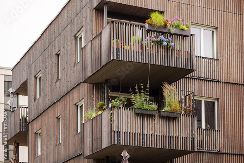 Wooden Facade of Modern High rise Apartment Building with Wood Balcony Railings. Wood Eco Exterior of Residential Multi family Housing.