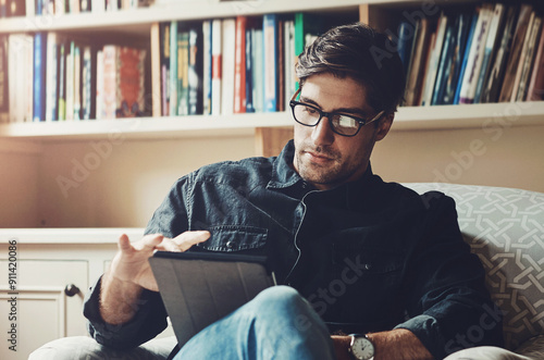 Reading, relax and tablet with man on sofa in living room of home for break, comfort or weekend time off. Ebook, glasses and technology with person chilling in apartment for peace, leisure or rest