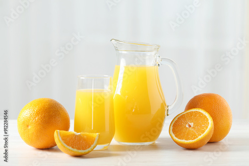 Tasty orange juice and fresh fruits on white wooden table