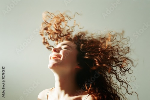 A person joyfully tossing their curly hair, with bright sunlight enhancing the dynamic motion, epitomizing freedom.