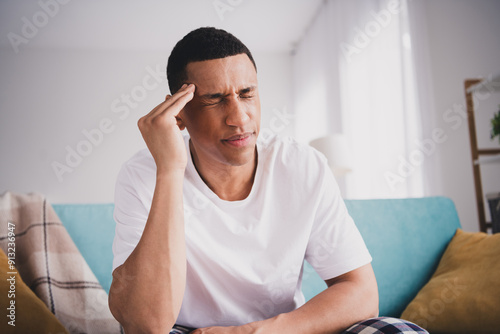 Photo of depressed sad guy nightwear pajama having headache sitting couch indoors room home house