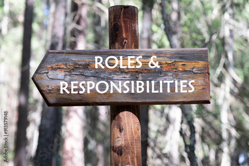 ROLES and RESPONSIBILITIES text written on a wooden signpost against a forest background